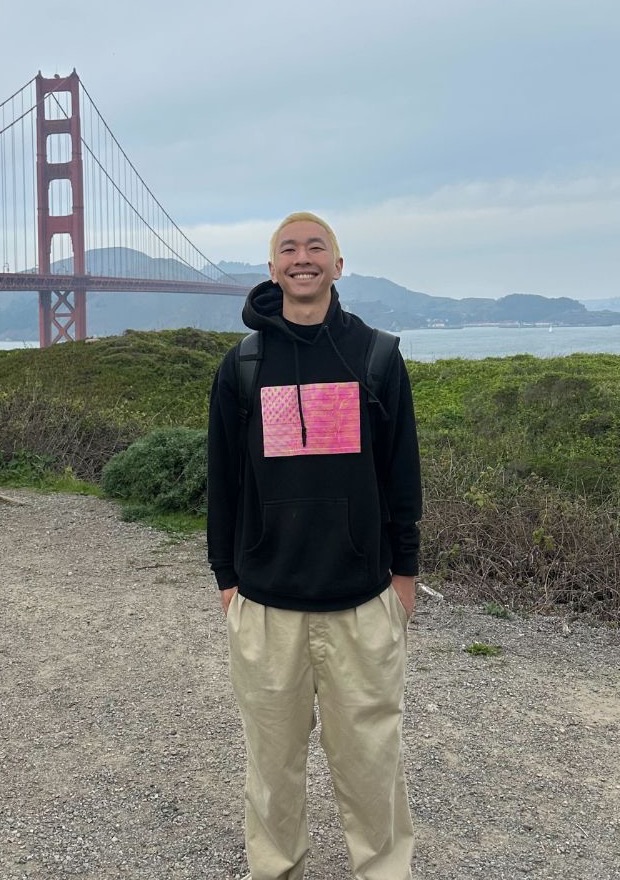 Jimmy Huang smiling in front of the Golden Gate Bridge