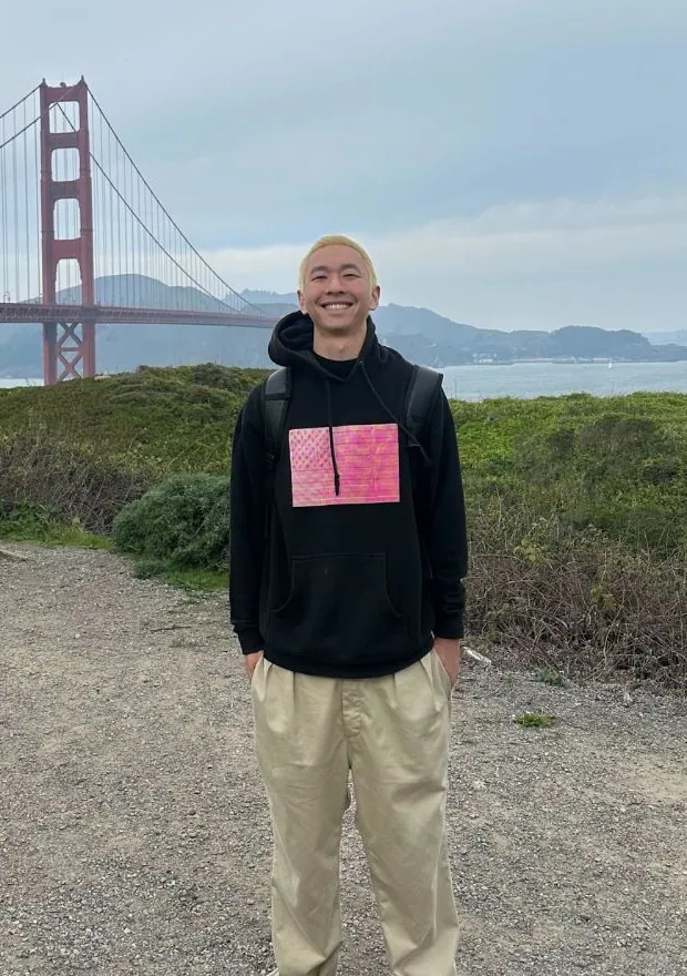 Jimmy Huang smiling in front of the Golden Gate Bridge